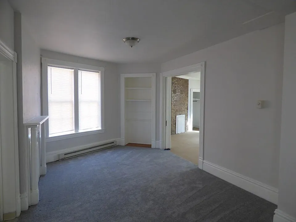 Living room with decorative fireplace and built in shelf