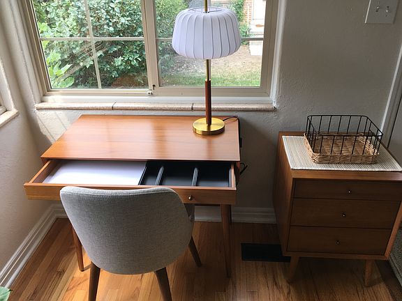 Office work area including new desk, small chest of drawers and a comfortable swivel chair from West Elm.