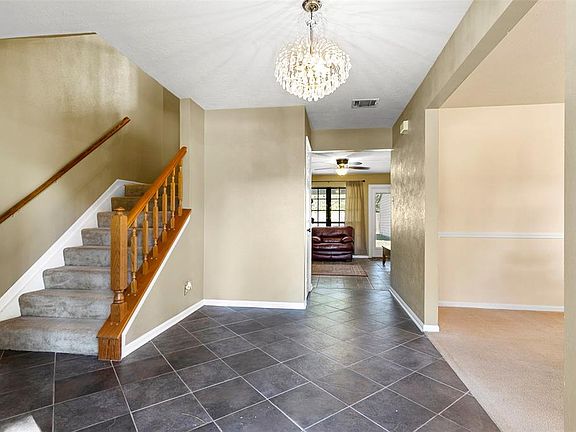 Welcome home! Tile on diagonal and pretty chandelier in the entry.