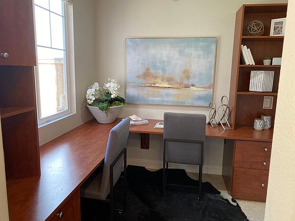 Office nook situated off kitchen has view to backyard and barndoor for privacy