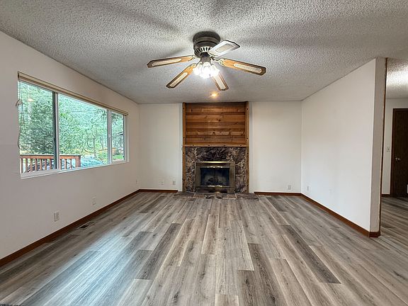 New LVP flooring in living room with wood burning fireplace