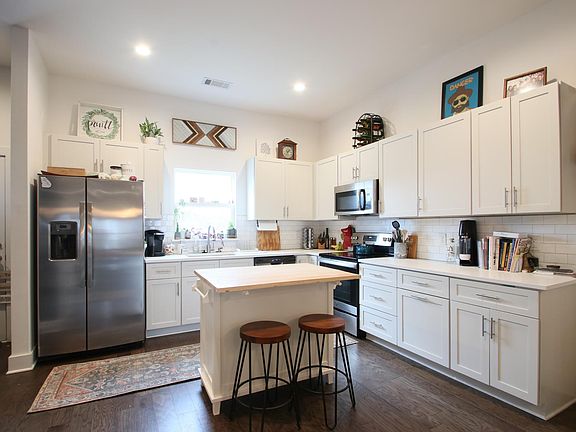 Large kitchen with plenty of cabinet space, stainless steel appliances, moveable island, and chalk wall.
