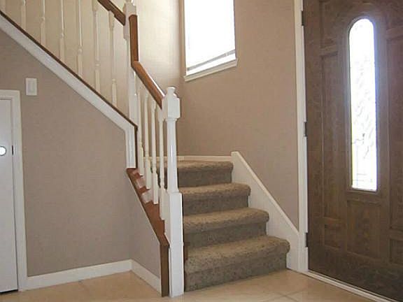 This entry features high ceilings and many windows for natural lighting.