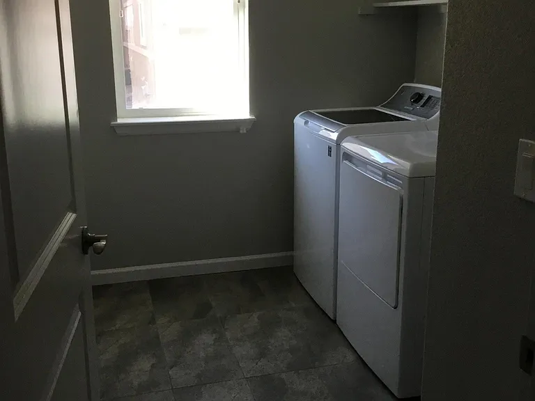 Spacious laundry room with shelf over the washer & dryer, room for laundry baskets and a door (so you can close off the area)