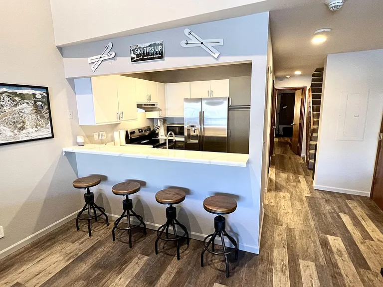 Kitchen with bar with seating for four, stainless appliances, refrigerator with filtered water and ice maker in door, Bosch quiet dishwasher
