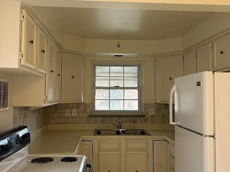 The kitchen is cozy and warm, equipped with a refrigerator and stove, lots of counters space.