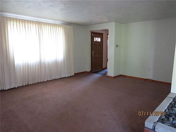 Living room with view of the entry way, with newer carpet.