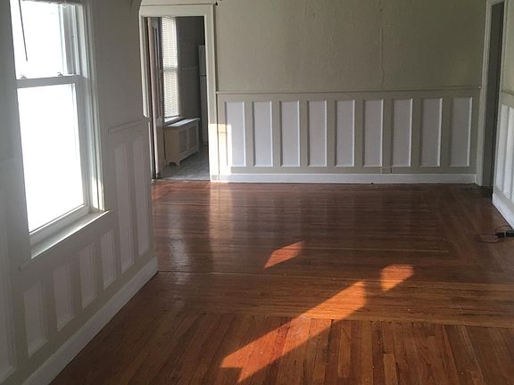 Main room offers beautiful hardwood floors, natural lighting from the windows and ceiling fans.