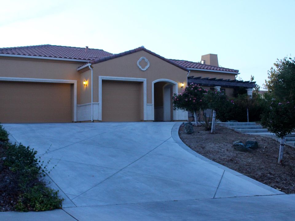 Street view of property with oversized, finished 3 car garage and expansive patio.
