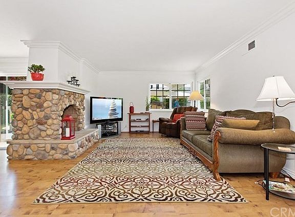 Spacious living room with stone fireplace and hardwood floors.