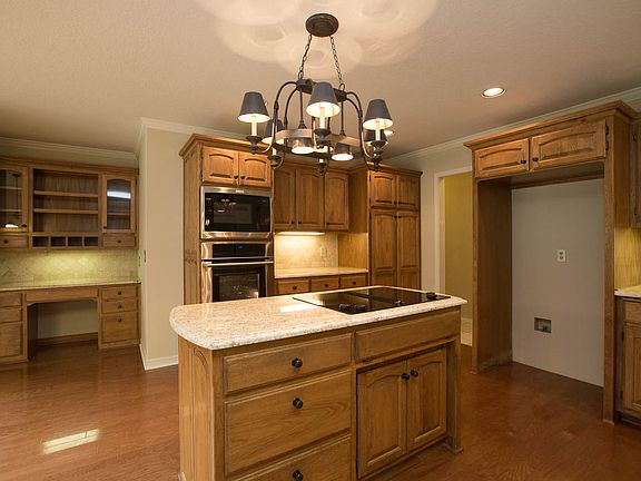 Granite center island boasts electric cooktop, storage with new hardware and new oil rubbed bronze light fixture.