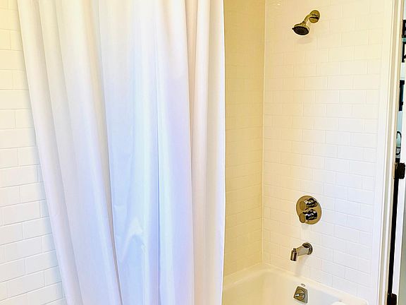1st floor cast-iron tub/shower, marble shelf, and marble floor.