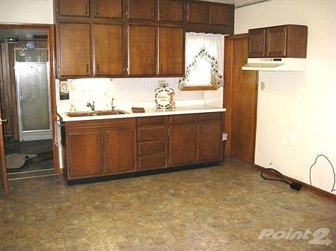 Kitchen with new vinyl flooring and plenty of space to add an island or cabinets