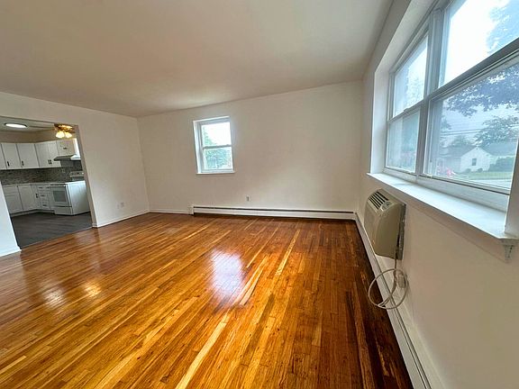 Entrance to living room. Three windows facing courtyard and tree lined street.