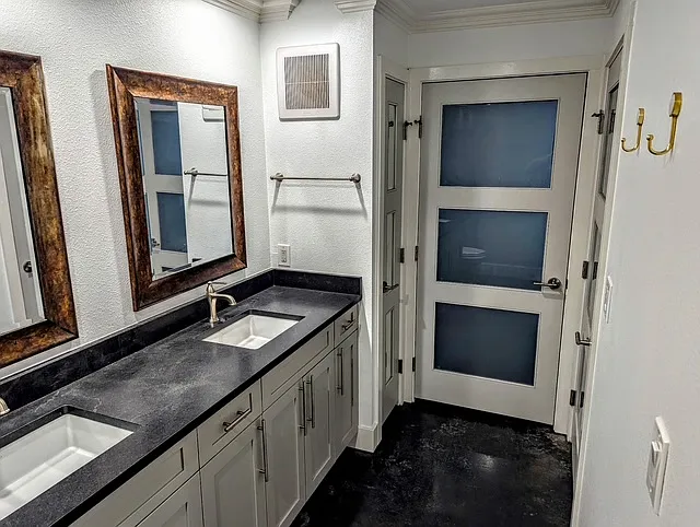 Beautiful bathroom with double vanity, linen closet, leathered granite countertops and plenty of cabinet space