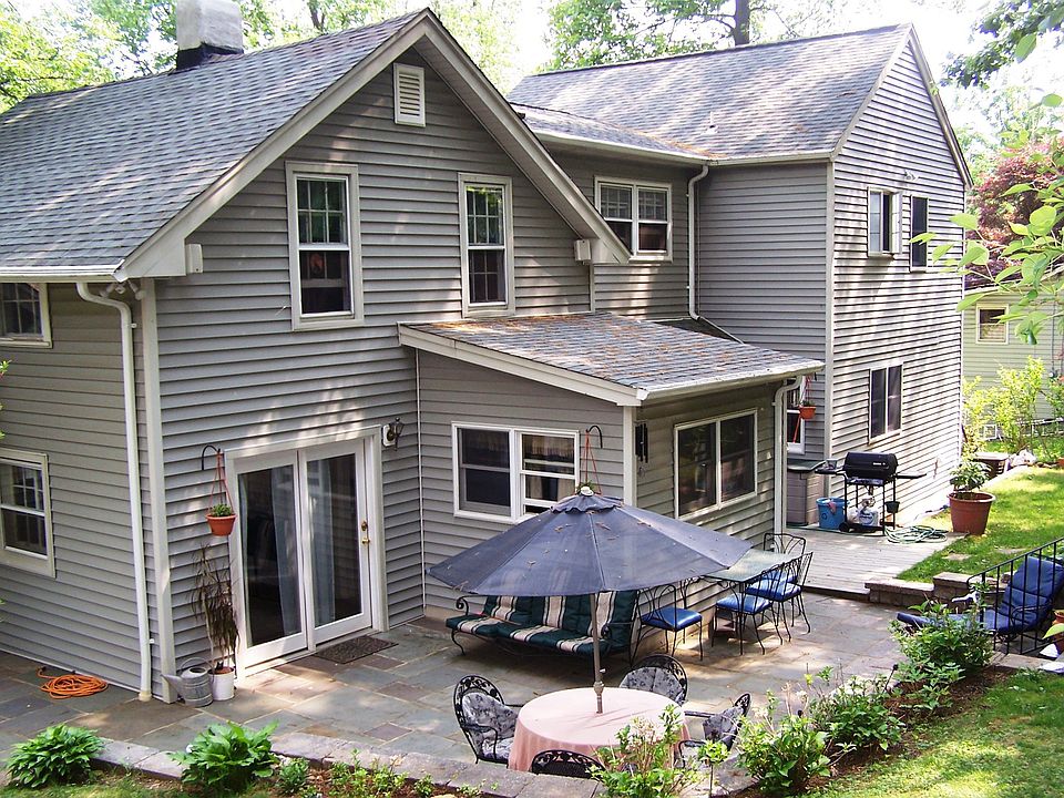 Back of home featuring a private slate patio, built in bbq, deck and bball ct.