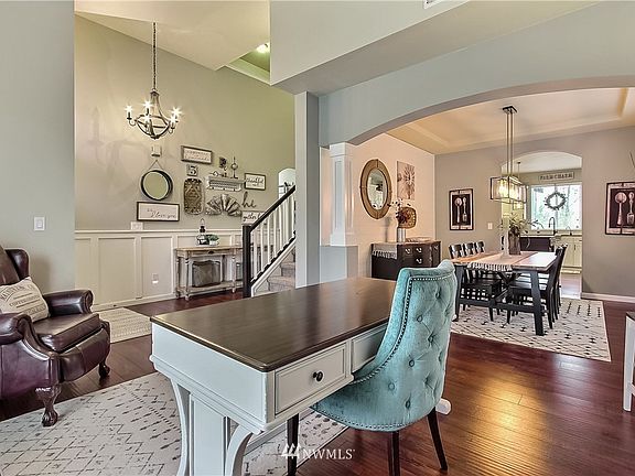 View from the formal living/office into the formal dining room. All fixtures have been replaced in this home! Really shows beautifully. Note also the hardwood floors. 