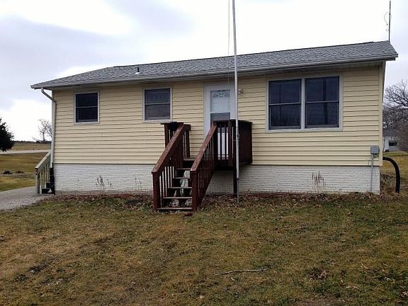 Front of house and front lawn with flag pole next to steps