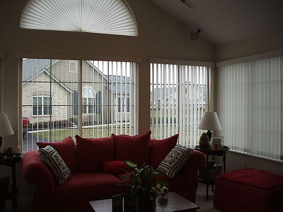 Veranda with cathedral ceiling, custom blinds, ceiling fan.