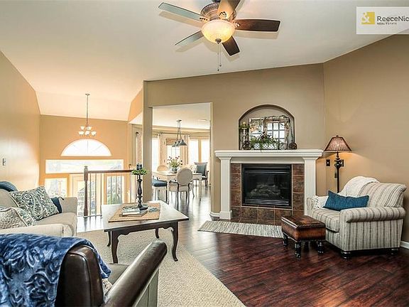 Great room with fireplace and ceiling fan. Steps to the back of the home walk out to a lower deck on the landing. Door off kitchen / eating area leads to the upper deck.