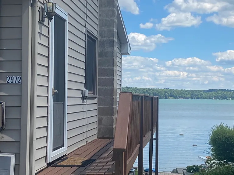 Walkway from parking spot .. up the 3 steps to the main entrance into the kitchen, or walk down the side deck to reach the main front deck. Walk the grass to the front yard , and lake