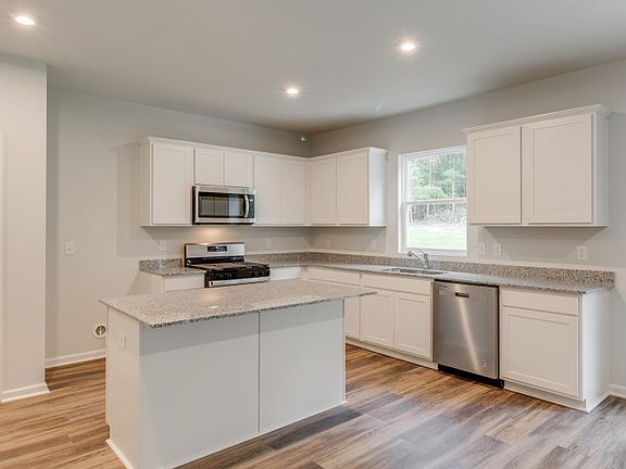 The bright white Rosella Kitchen features premium granite countertops and an island.