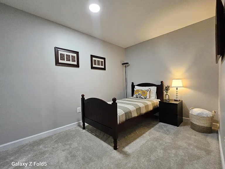 Twin bedroom with another walk in closet that boasts a dresser and plenty of storage.
