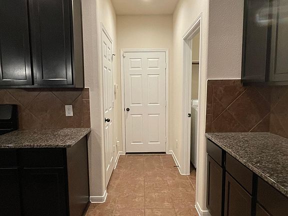 Hallway that leads to Pantry, Garage, and Laudry Room with storage space