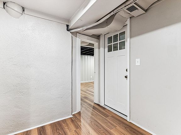 Basement foyer includes a solid wood exterior-style door. Laundry and stairs to exterior just outside the door.