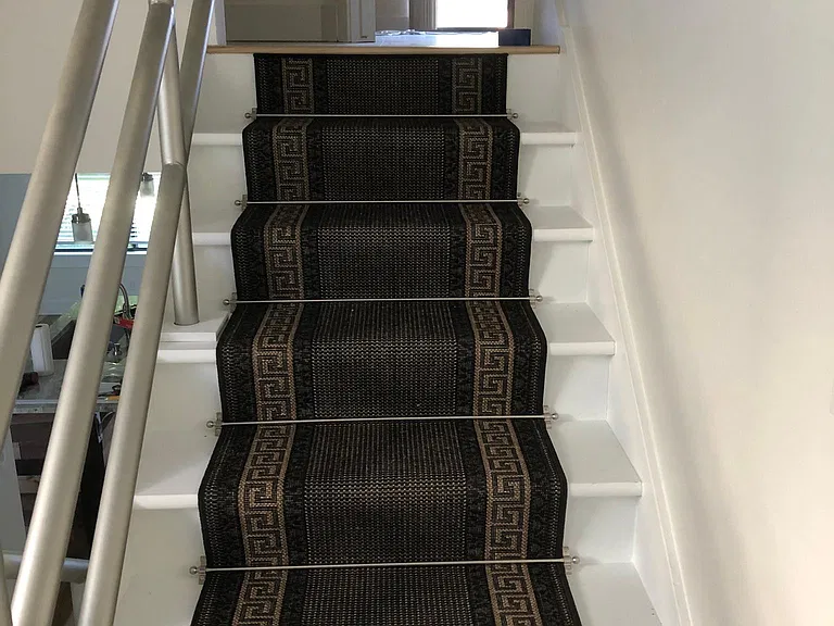 Stair runners accent the design of stairs leading to 2-bedrooms and 2nd bathroom on mid-level.