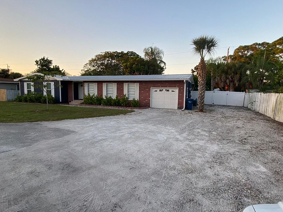 Front view of home with large driveway.