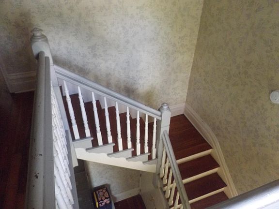 view of stairwell in front from landing with library section