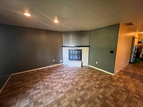 Living room fireplace with ceiling lights.