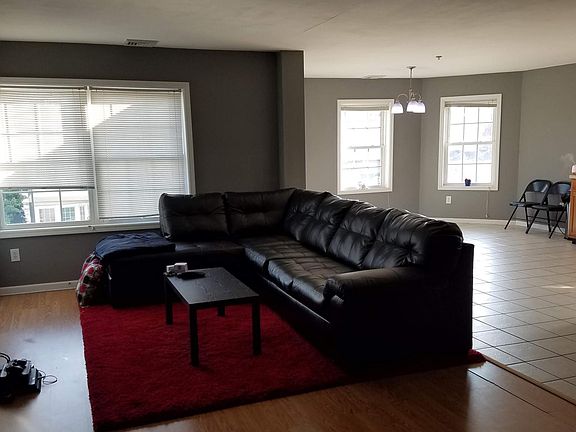 View of living room, kitchen, and bay windows from the entrance.