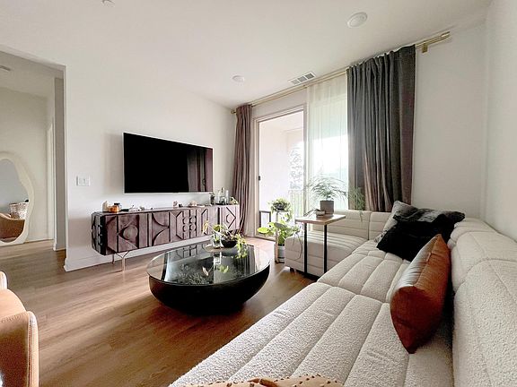 Living room with southeast-facing patio with tons of natural light and a view to the Clubhouse and courtyard
