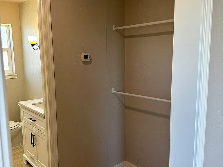 Right side of Walking closet with cabinet for primary bedroom and entrance to the insuite bathroom