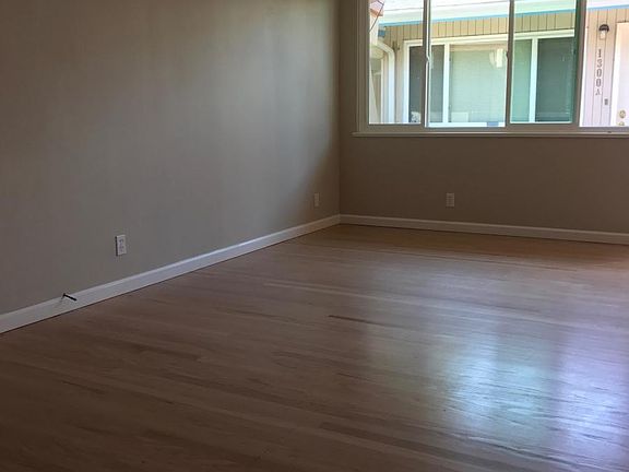 Living room with refinished hardwood floors and wood-burning