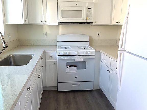 New kitchen with quartz countertop, new cabinets, and new appliances (fridge, stove, and microwave)