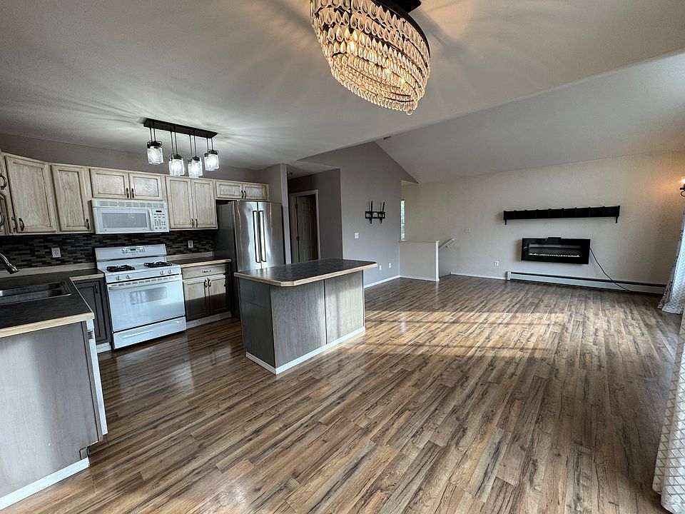 Upstairs kitchen, dining, and living room with electric fireplace and tv mount