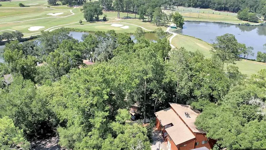 Aerial view of golf course and lake and property