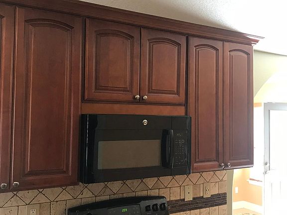 Beautiful Ceiling height Cabinets with Crown molding & Soft-close drawers, Granite Countertops, Travertine Backsplash & Smooth-top Stove.