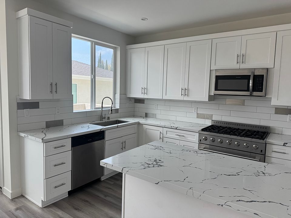 Cabinets all over this pretty kitchen. Pantry and fun island for all your needs