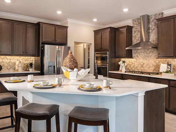 A large, diamond-shaped center island with granite countertops provides room for preparing and servi