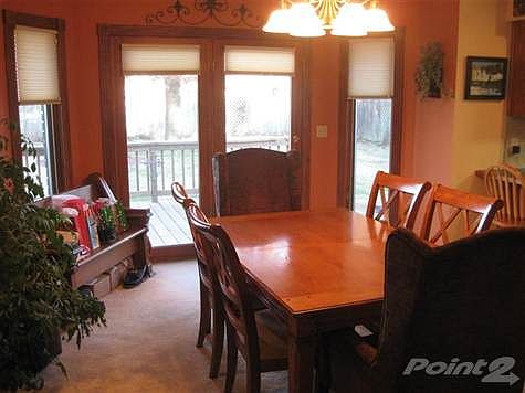 Dining area with lots of windows allowing the east light to filter in and doors opening to the wooden back deck.  A great place for bar-b-queing and just enjoying the outdoors.