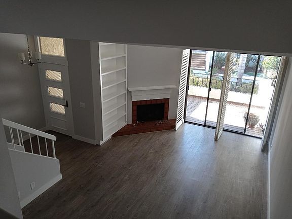 Living area complete with gas fireplace, built in bookcase, and steps to your private front patio.