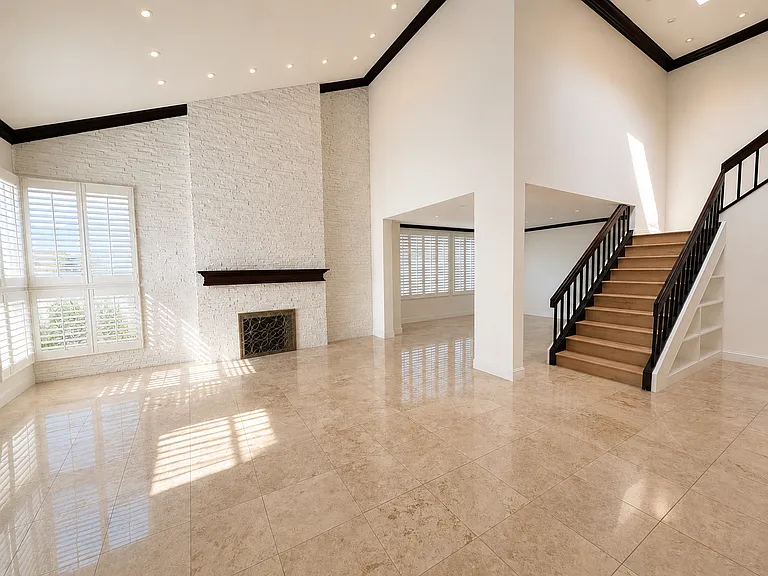 The vaulted ceiling and skylight flood the living room with natural light, complemented by windows and recessed lighting for a bright, airy feel.