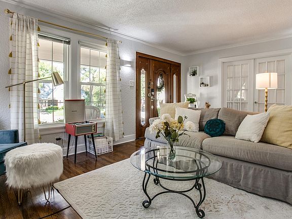 beautiful den looks on to a great covered front porch where you can see a lovely neighborhood