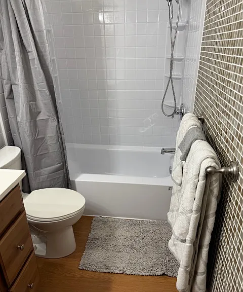 Bath with new Bath Fitters tub and show walls and built-in storage
