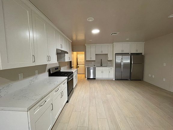 All brand-new appliances in the large open kitchen include a dishwasher and two full-sized refrigerators.
