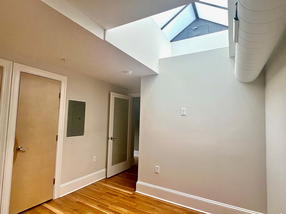 Bedroom with door to hallway and skylight shown